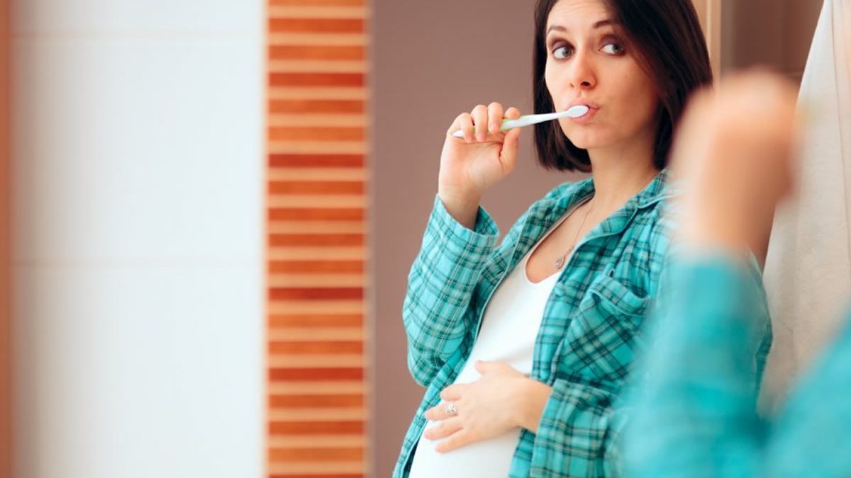 Donna incinta si lava i denti. Igiene orale in gravidanza.
