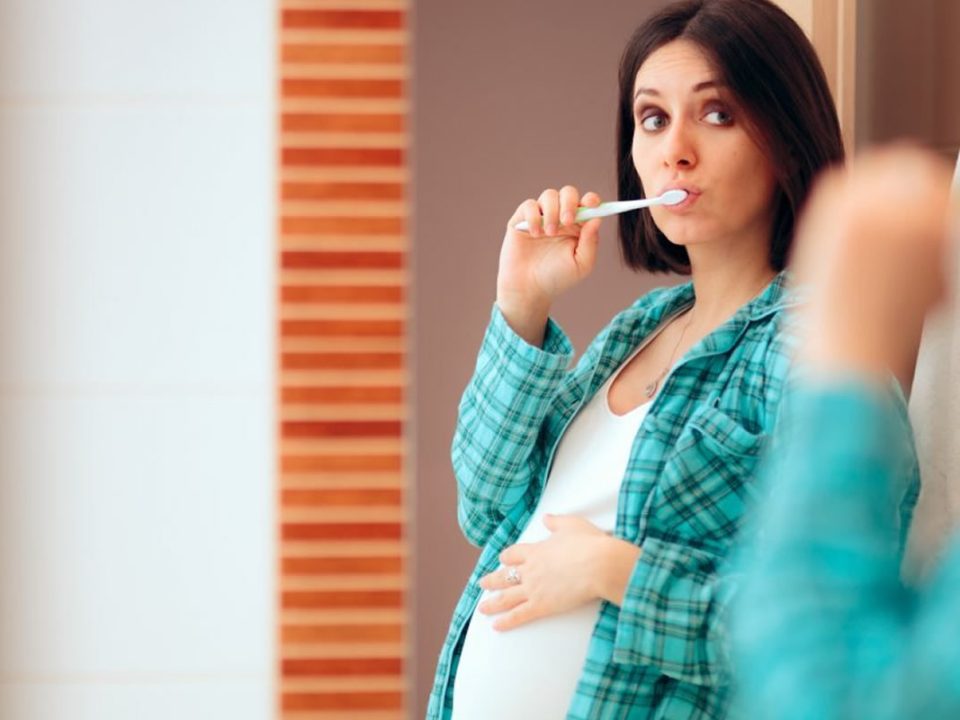 Donna incinta si lava i denti. Igiene orale in gravidanza.