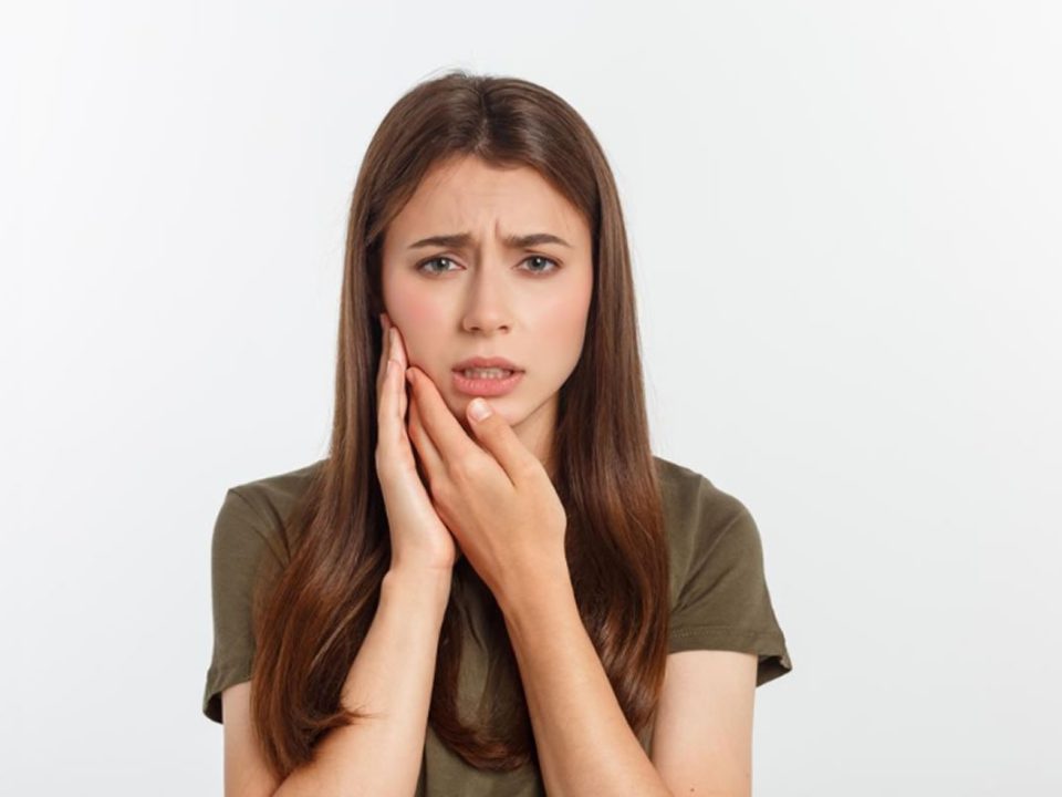 Donna con dolore dentale: come curare la parodontite e alleviare il fastidio.